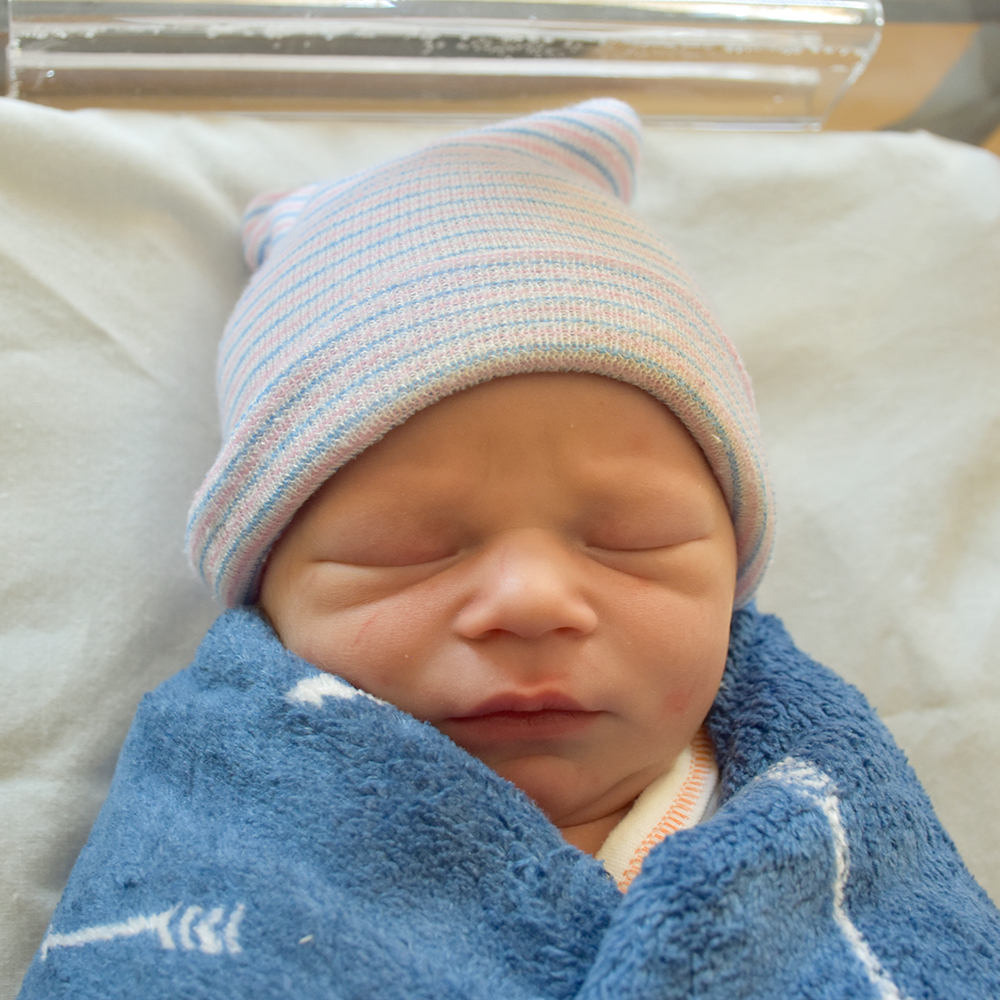 headshot of baby brayson, wrapped in a blue blanket